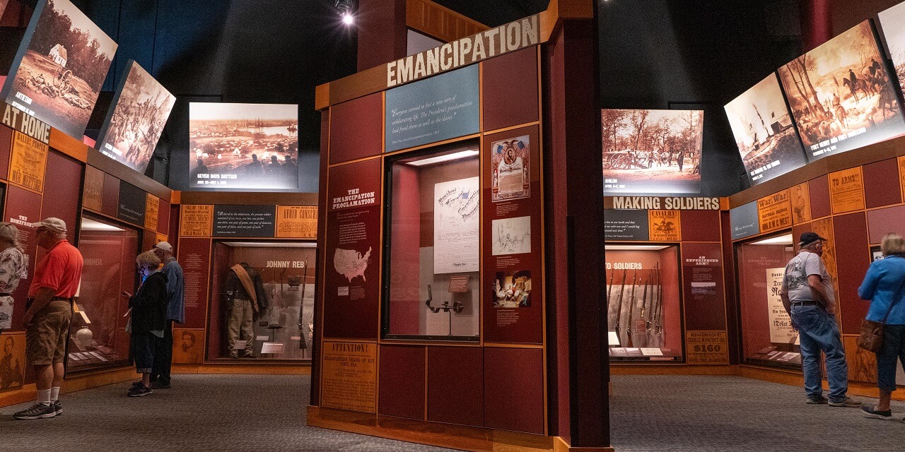Museum visitors view various historical exhibits and documents in a Civil War gallery
