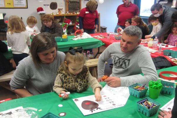 child and parents making a reindeer craft