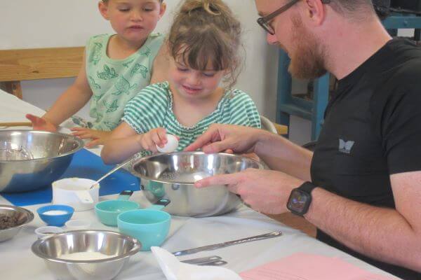father and children mixing baking ingredients