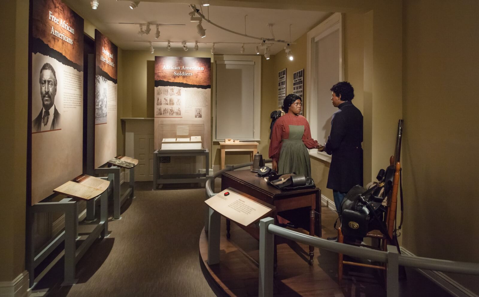 A museum display featuring mannequins of an African American man and woman with information panels