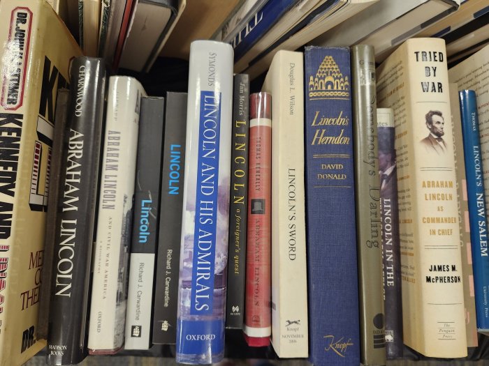 A bookshelf filled with various biography and history books focusing on Abraham Lincoln